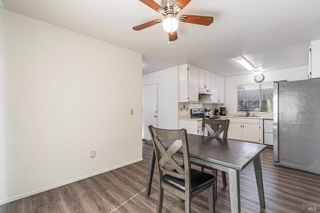 dining area with dark wood-type flooring, ceiling fan, a textured ceiling, and baseboards