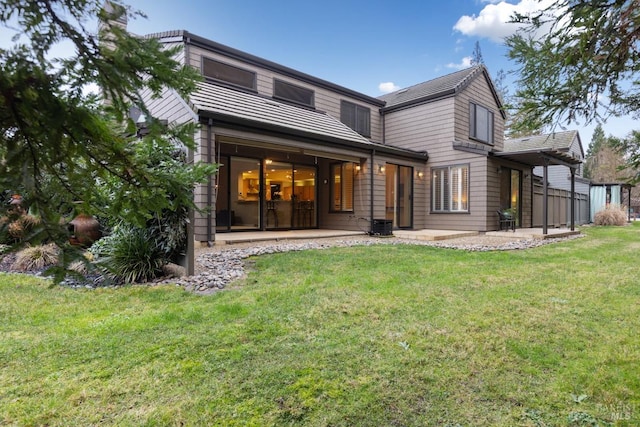 rear view of house featuring a patio area and a yard