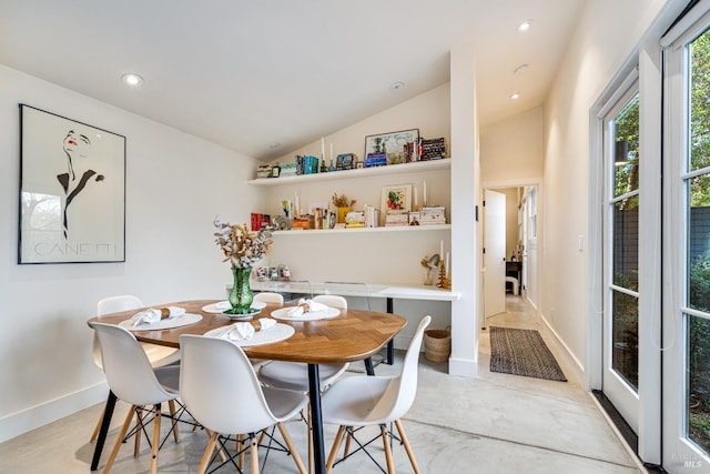 dining room with lofted ceiling, concrete floors, baseboards, and recessed lighting