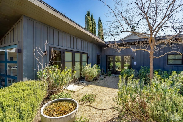 back of property with board and batten siding and french doors