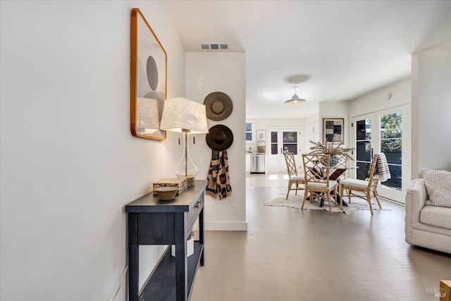 dining room featuring french doors, visible vents, baseboards, and wood finished floors