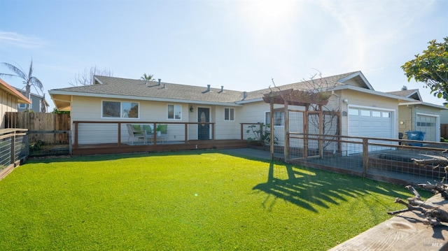 back of house featuring a garage, a yard, and a wooden deck