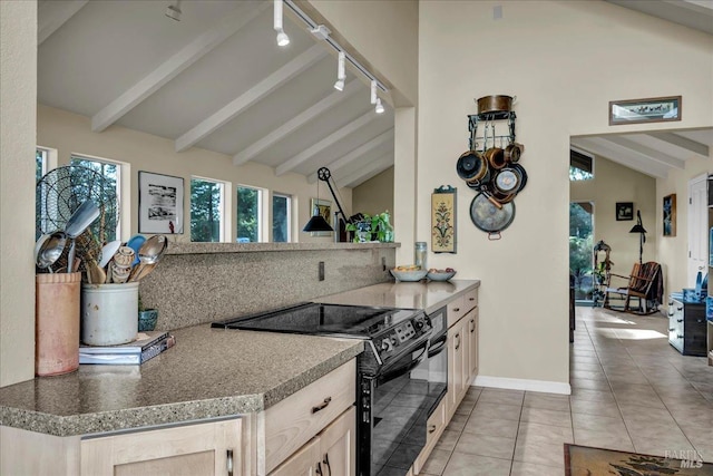 kitchen featuring lofted ceiling with beams, electric range, light tile patterned flooring, light brown cabinets, and track lighting