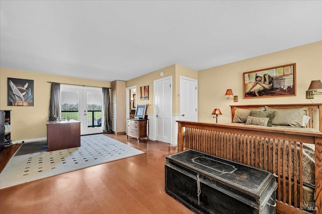 bedroom with access to exterior, hardwood / wood-style floors, and french doors