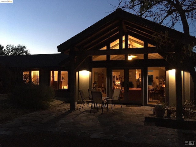 back house at dusk with a patio