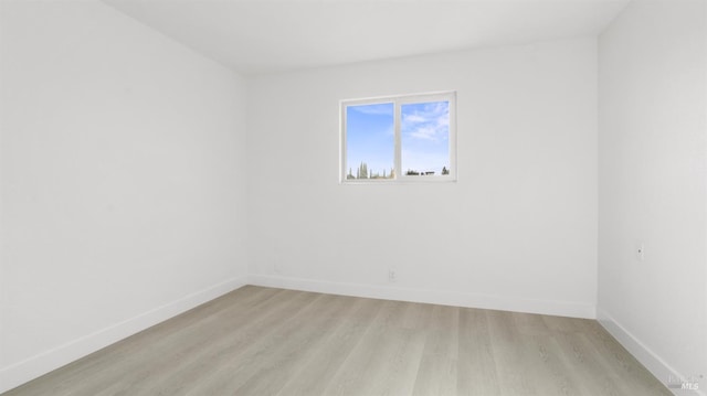 spare room with light wood-style flooring and baseboards