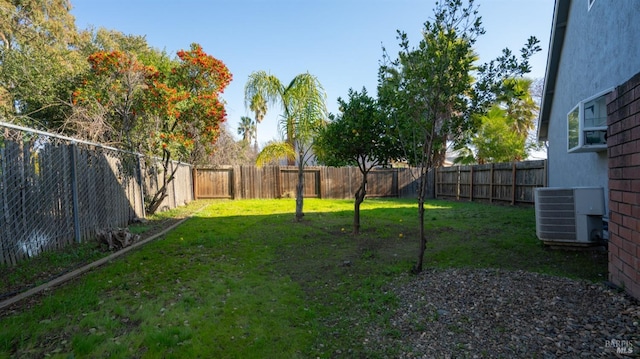 view of yard featuring central AC and a fenced backyard