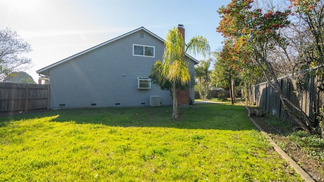 exterior space with crawl space, a fenced backyard, a yard, and stucco siding