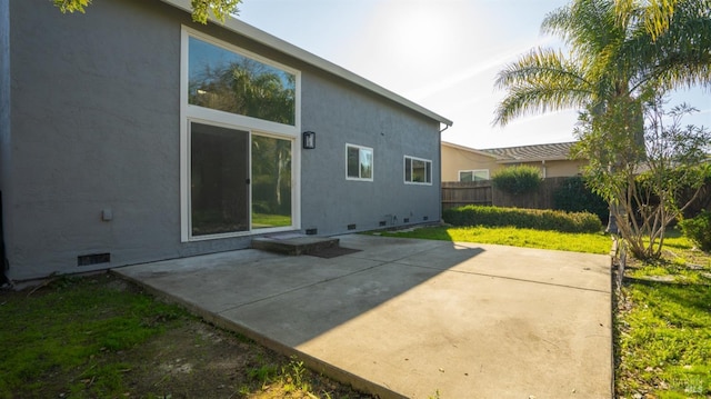 back of property with crawl space, a patio area, fence, and stucco siding