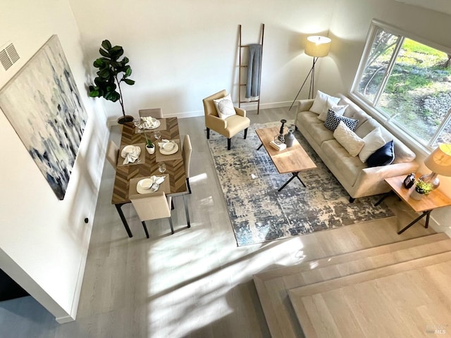 living area featuring wood finished floors, visible vents, and baseboards