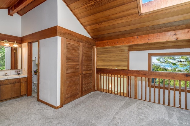 bonus room with lofted ceiling with beams, wooden ceiling, a sink, and light colored carpet