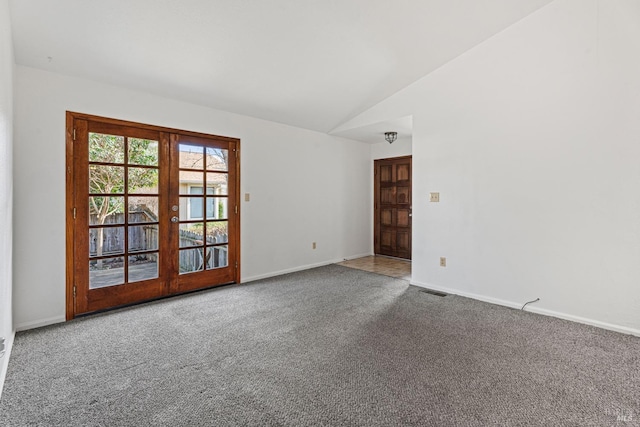 carpeted empty room with lofted ceiling and french doors