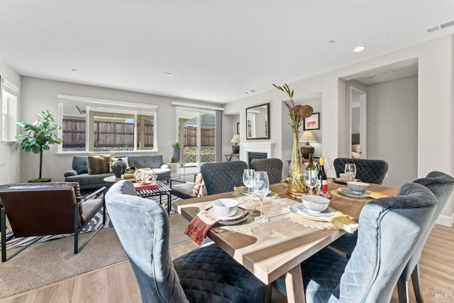 dining area with visible vents, recessed lighting, a fireplace, and light wood-type flooring