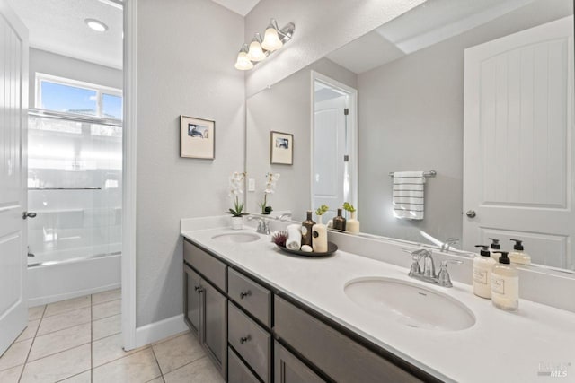 bathroom with tile patterned floors, double vanity, baseboards, and a sink