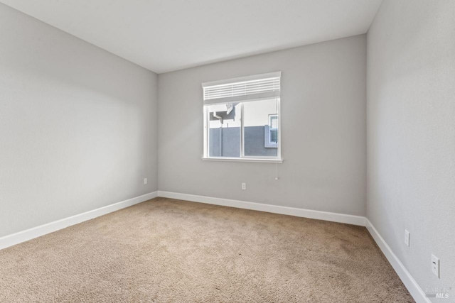 carpeted spare room with baseboards