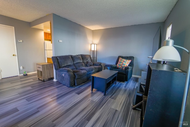 living room with a textured ceiling and dark hardwood / wood-style floors