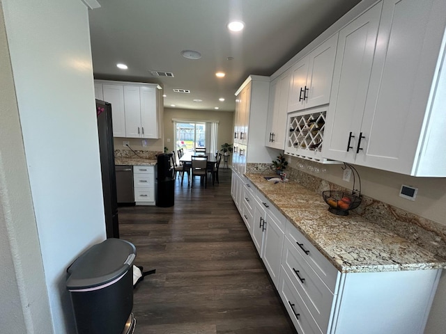 kitchen featuring white cabinetry, dark hardwood / wood-style flooring, light stone countertops, and dishwasher