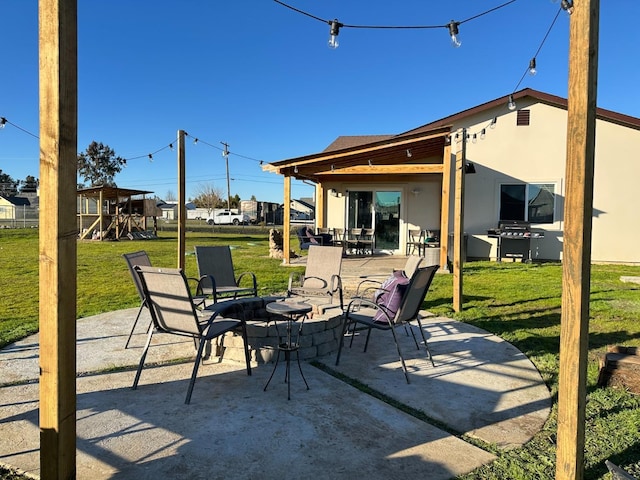 view of patio featuring a grill, a playground, and an outdoor fire pit