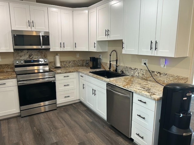 kitchen with stainless steel appliances, white cabinetry, and sink