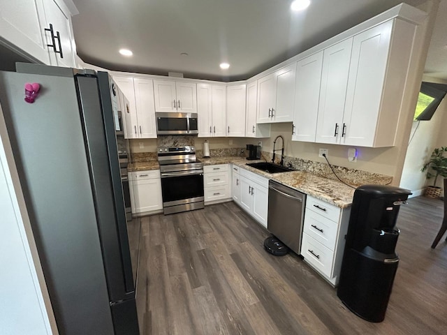 kitchen featuring sink, light stone counters, dark hardwood / wood-style flooring, stainless steel appliances, and white cabinets