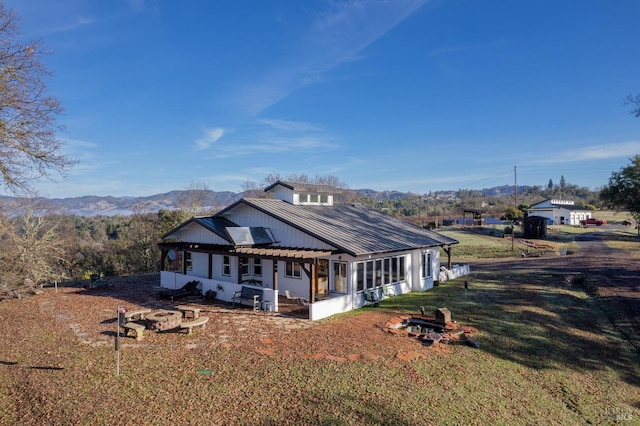 view of front of house featuring a mountain view, a pergola, and a front lawn