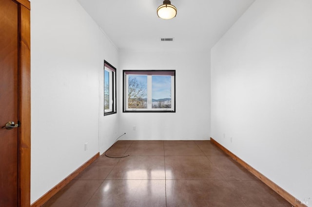 unfurnished room featuring dark tile patterned floors