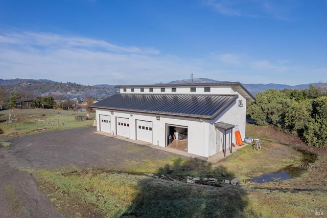 exterior space with a mountain view, a garage, and an outbuilding