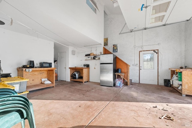 garage featuring a workshop area and stainless steel fridge