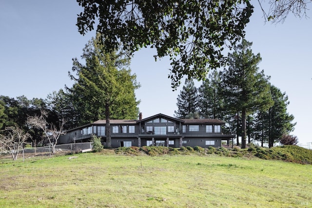 rear view of house featuring a yard