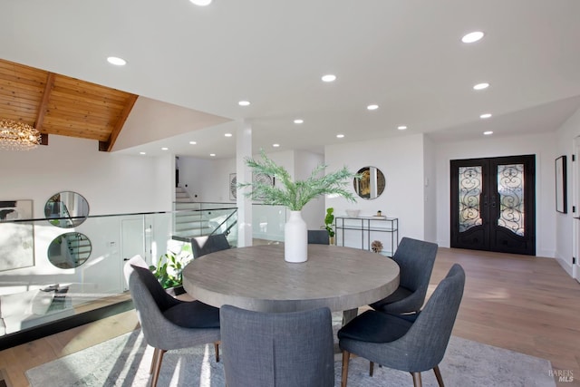 dining room with french doors, a notable chandelier, light hardwood / wood-style floors, and wooden ceiling