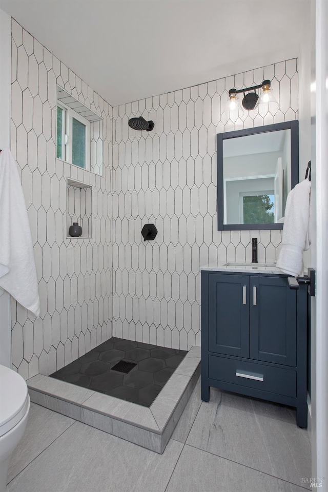 bathroom featuring tile walls, toilet, walk in shower, and vanity