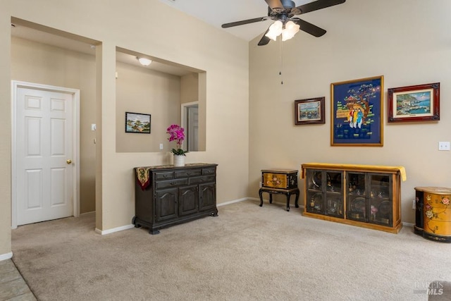 interior space with ceiling fan and light colored carpet