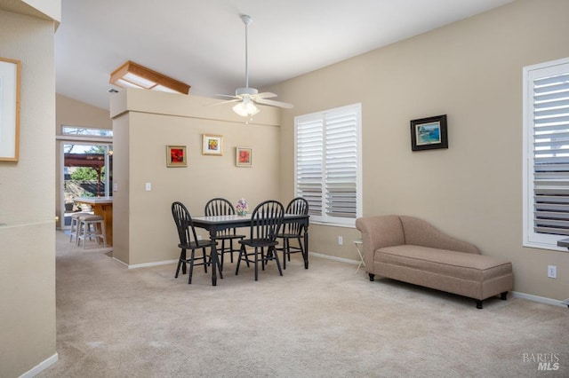 carpeted dining room featuring ceiling fan and vaulted ceiling