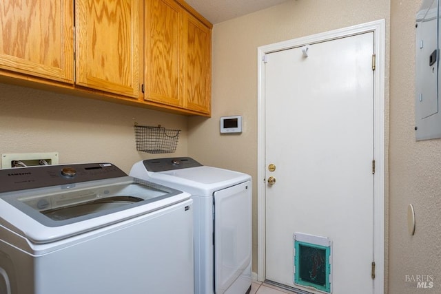 laundry room featuring cabinets, washing machine and clothes dryer, and electric panel