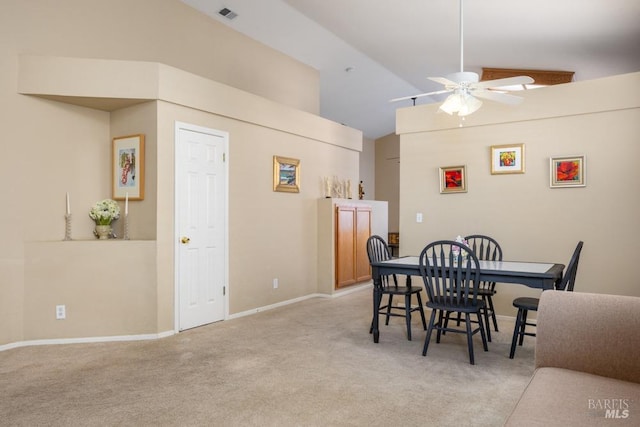 dining space with high vaulted ceiling, light colored carpet, and ceiling fan