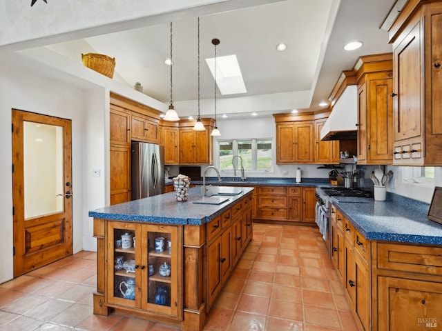 kitchen with a sink, stainless steel appliances, dark countertops, and custom exhaust hood