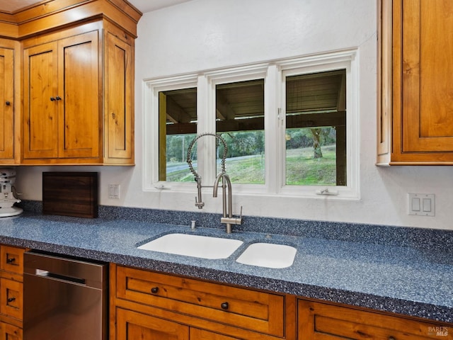 kitchen with dishwasher, dark countertops, and brown cabinets