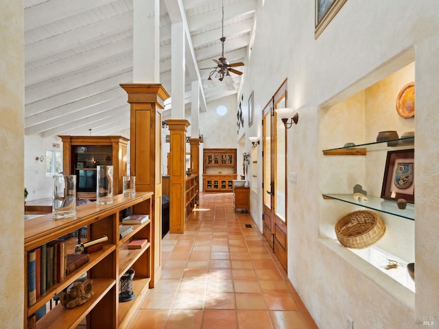 corridor featuring light tile patterned floors, high vaulted ceiling, and beam ceiling