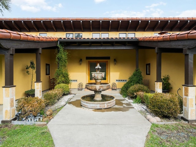 exterior space featuring a tiled roof and stucco siding