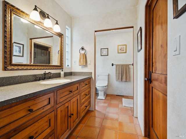 bathroom with toilet, vanity, and tile patterned floors