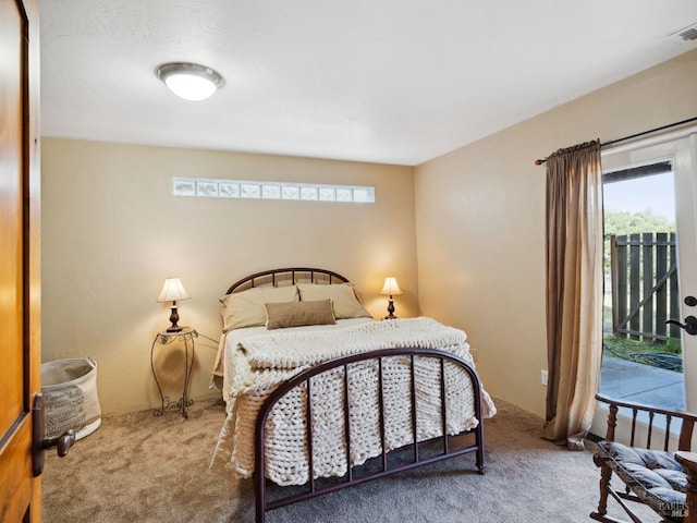 bedroom with multiple windows, carpet flooring, and access to exterior