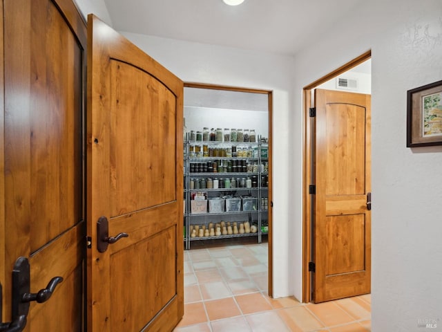 hall with light tile patterned floors and visible vents