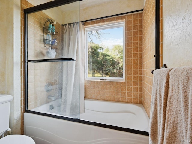 full bath featuring toilet and shower / bath combination with glass door