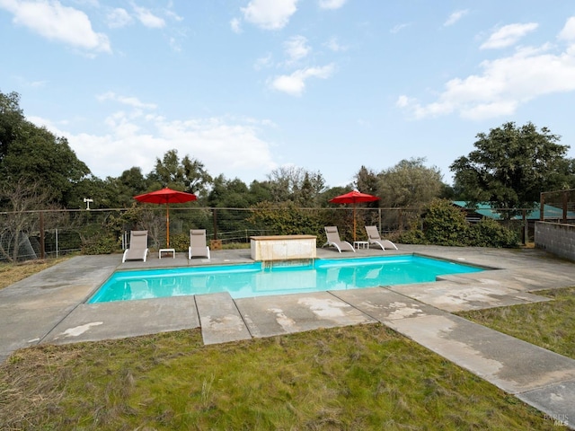 view of pool with a patio, a lawn, fence, and a fenced in pool