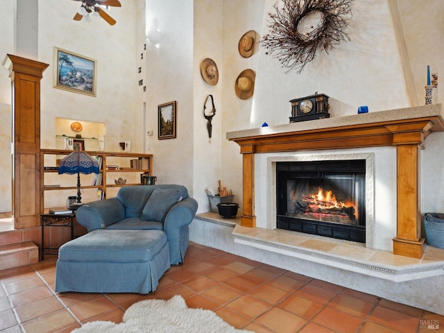 living area featuring light tile patterned floors, a high ceiling, and a premium fireplace