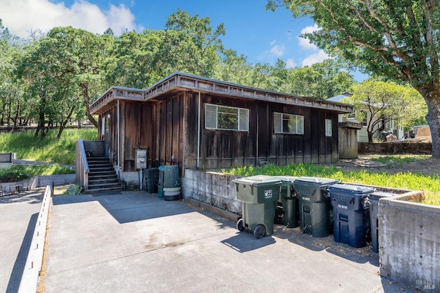 exterior space with board and batten siding and stairway