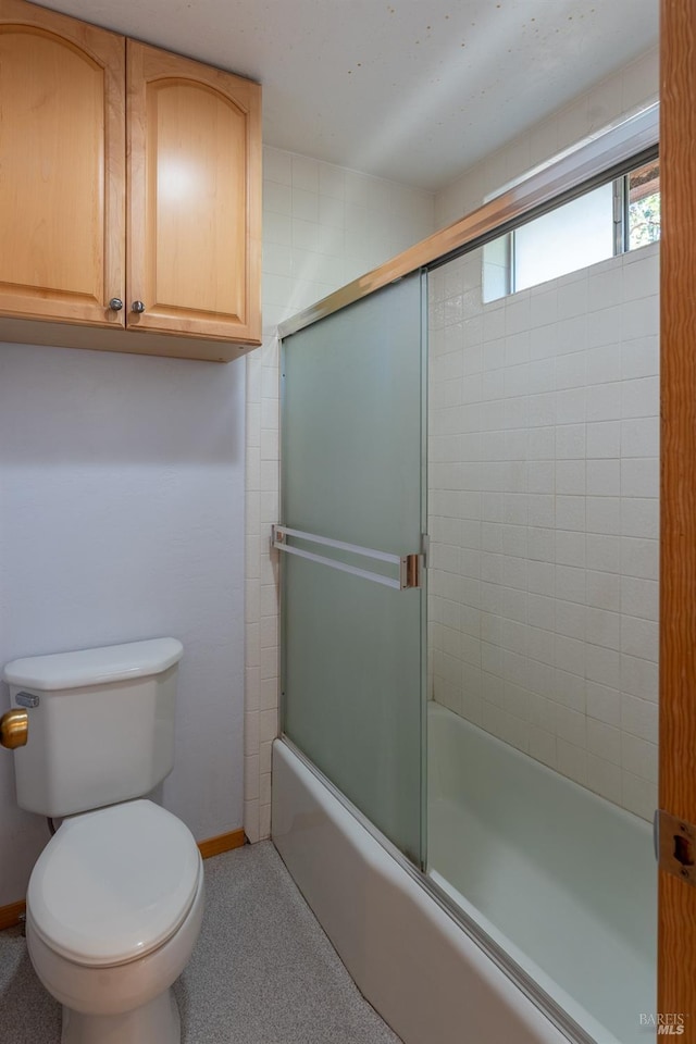 full bath featuring toilet, shower / bath combination with glass door, and baseboards