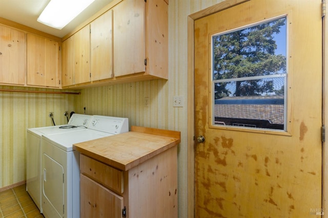 clothes washing area featuring light tile patterned flooring, washer and dryer, cabinet space, and wallpapered walls