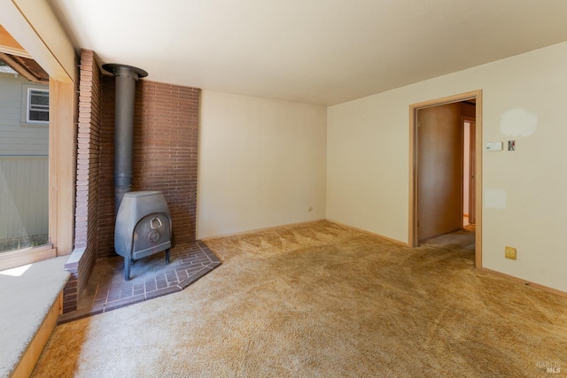 unfurnished living room featuring carpet floors and a wood stove