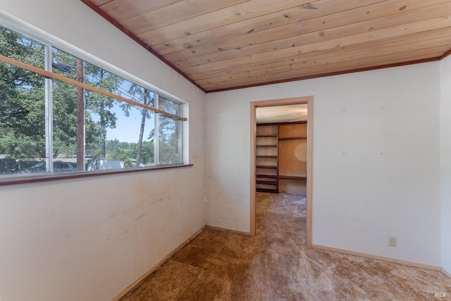 carpeted empty room with wooden ceiling and baseboards